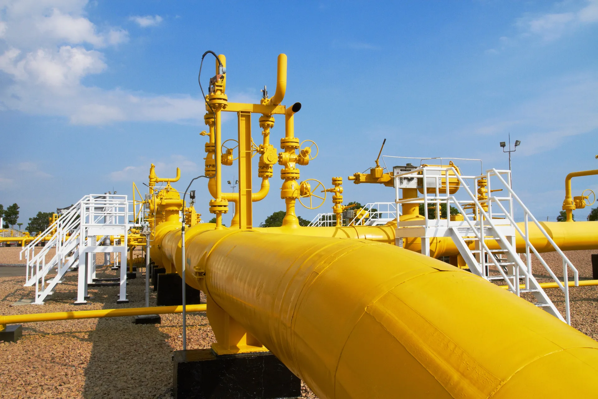 Yellow natural gas pipeline and valves at a gas facility